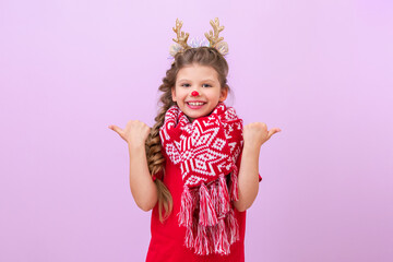 A little girl with a New Year's deer mask is pointing her fingers in different directions.