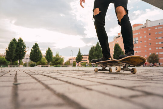 Crop legs riding skateboard in park