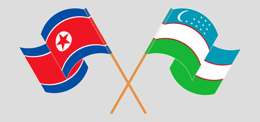 Crossed and waving flags of North Korea and Uzbekistan