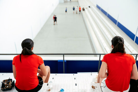 Rear view of female players sitting on bleacher in a traditional spanish game "Valencian Pelota" preparing to play