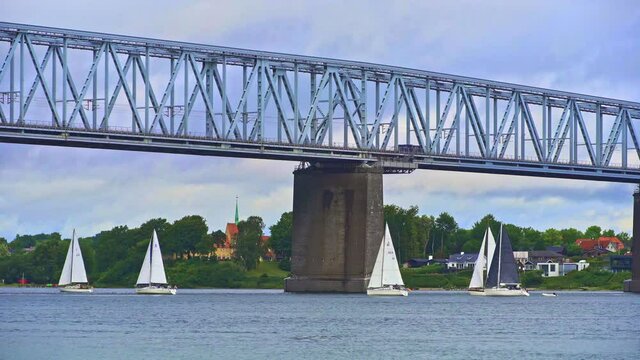 Sailboats cross the Little Belt Strait passing under the Little Belt Bridge. Denmark, Europe