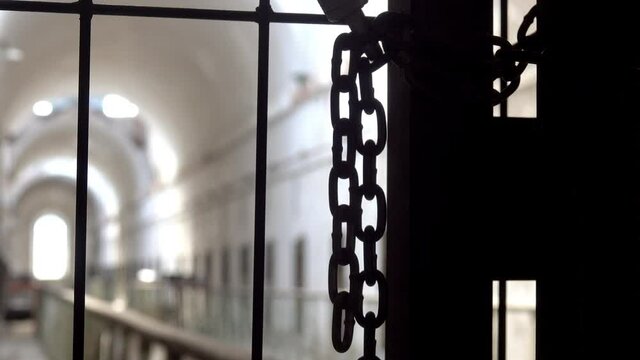 Chains hang from gate at entrance to prison cellblock.
