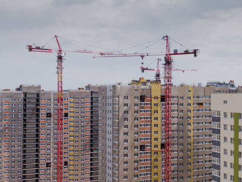 tower cranes in front of the houses being built