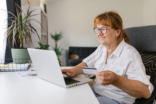 Senior woman using credit card for online payment 
