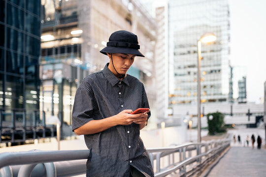 Young man standing using phone in the city