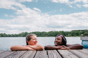 Laughin diverse girls by a lake