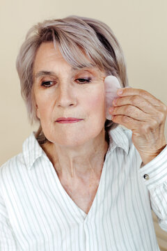 Senior woman massaging face