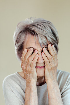 Senior woman covering eyes with hands