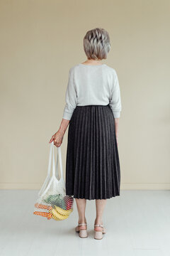 Anonymous senior customer with groceries in eco bag