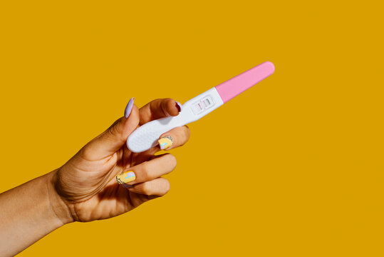 woman holds a positive pregnancy test