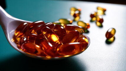 Closeup view of  Omega3 capsules  in white big spoon  with background 