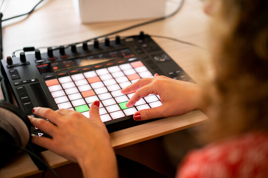 Woman playing midi controller at home music studio