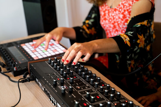 Woman playing midi controller at home music studio