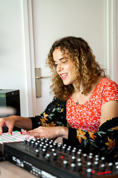 Woman playing midi controller at home music studio