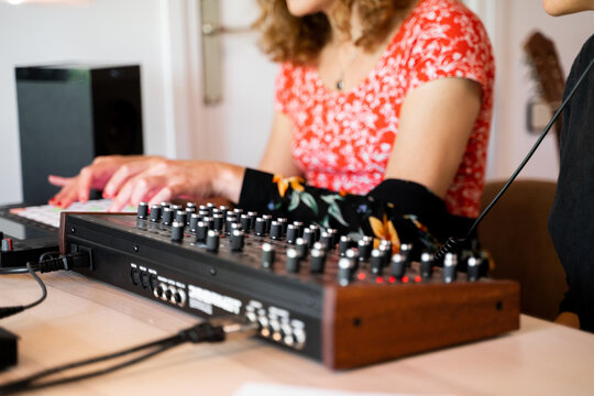 Friends playing midi controller at home music studio
