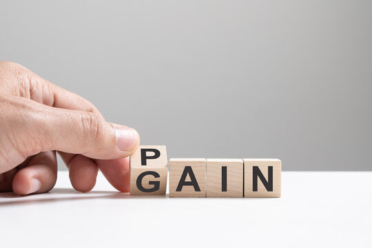No pain no gain concept, hand flip wood cube change the word from pain to gain