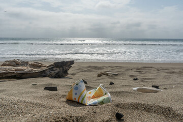 Plastic cup  polluting the beach on a sunny day