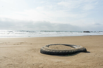 Polluting tire on the beach