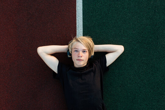 Dreamy young man lying on running track