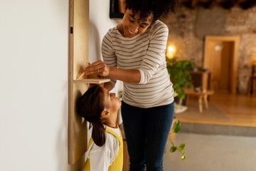 Mom measuring the height of her daughter
