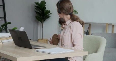 Joyful boy playing and disturbing and annoying his mother, who scolds him and sends him away. Difficulties of online work and learning with hyperactive children.