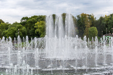 Splashing water of fountain inject from ground showing in public park.