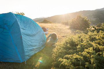 Kid installing tent at camping area