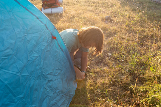 Boy installing tent