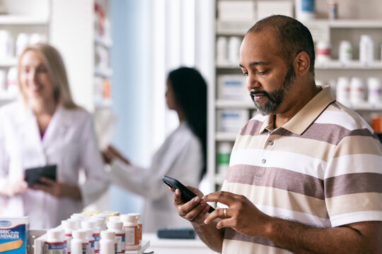 RX: Male Customer Checks Smart Phone