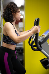 Fototapeta premium exercising with elliptical bi racial model Jamaican and Italiano fitness model 
