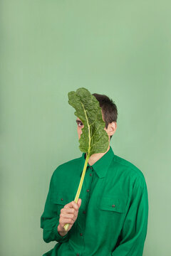 Man hiding behind green chard