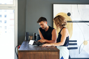 Colleagues using tablet at reception desk