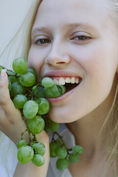 Young girl aeting green grapes