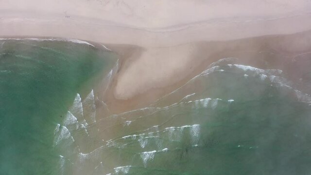 Waves from the Atlantic Ocean wash onto a scenic beach in Chatham, Cape Cod, Massachusetts. This beautiful peninsula is a popular vacation destination during summer months.
