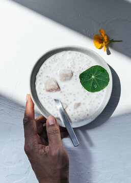 Hand holding bowl of coconut taro sago 