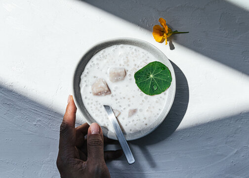 Hand holding bowl of coconut taro sago 