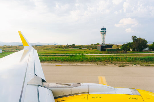 An airplane at the airport with the control tower

