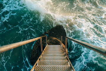 Waves at bottom of ladder to sea