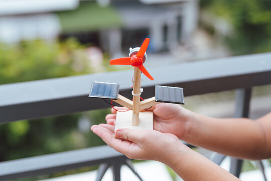 Asian boy playing solar cell toy.