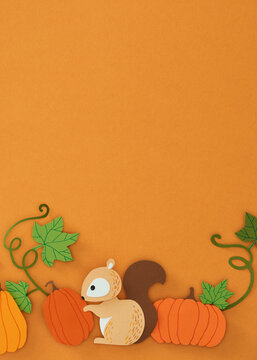 Closeup of a squirrel stealing a miniature pumpkin