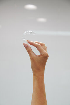 Hand holding orthodontics retainer