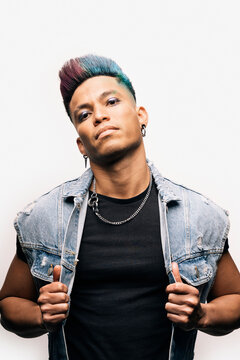 Punk man holding his jacket and looking at camera