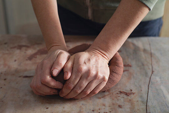 Hands kneading clay