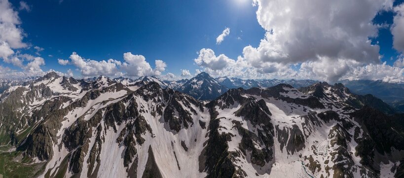 sunny landscape with a snow-covered mountain range
