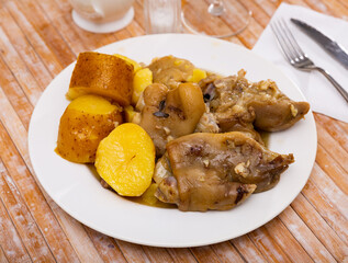 Grilled pig feet with potato on plate, homemade dinner