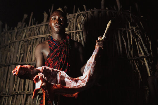 Masai man holding a goat.