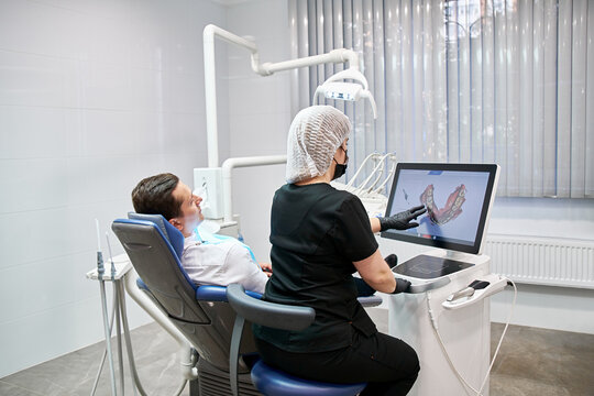 The dentist shows the patient a picture of the jaw