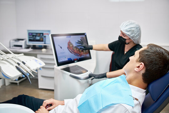 The dentist shows the patient the scan result