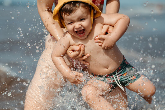 Laughing baby in mom's arms.