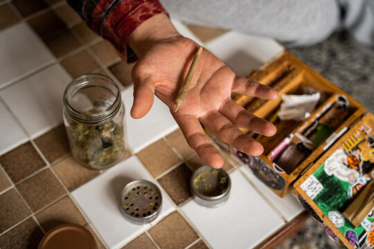 Man rolling cannabis joint at home